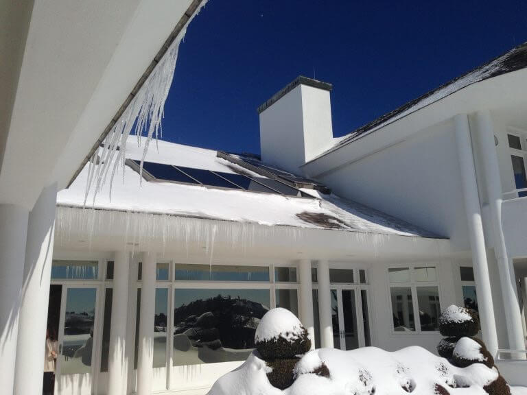 View of home covered in ice from snow
