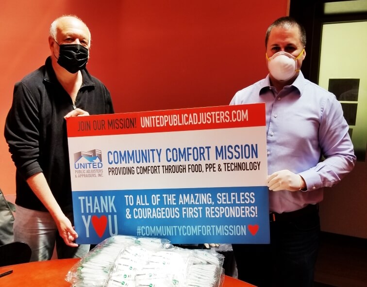 Men holding up "Community Comfort Mission" sign