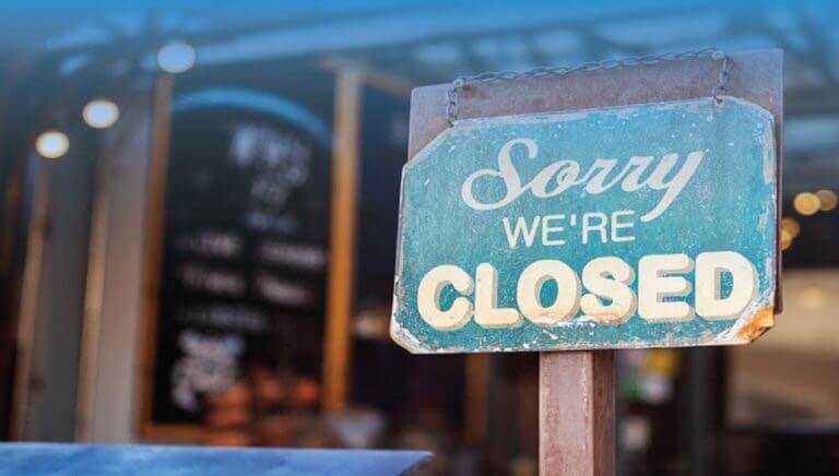 Sign of "Sorry We're Closed" sign in front of business