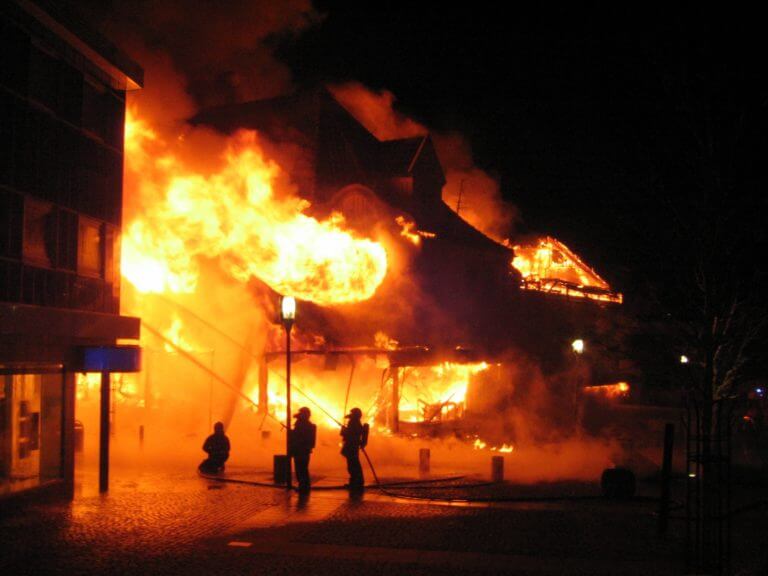 Building in full flaming inferno, and the firefighters fighting to get control of the flames