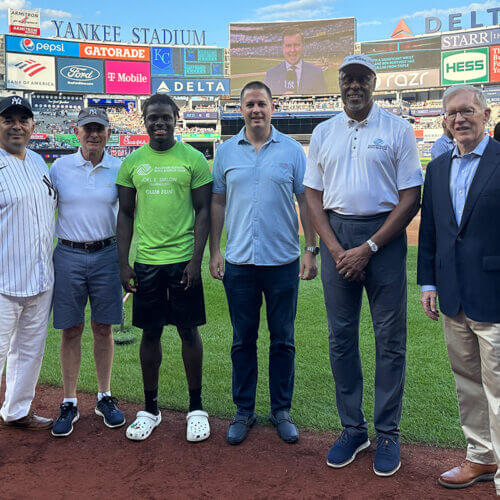 owner with individuals at baseball game